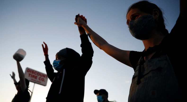 Demonstrators join hands Thursday, May 28, 2020, in St. Paul.