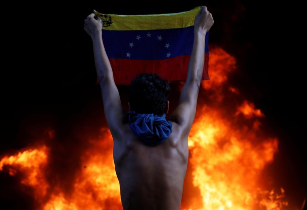 A protester holds a national flag as a bank branch, housed in the magistracy of the Supreme Court of