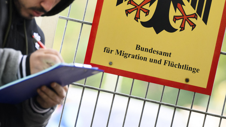 Urząd Recepcyjny Dolnej Saksonii w ośrodku w Brunszwiku obok znaku Federalnego Urzędu ds. Migracji i Uchodźców, Brunszwik, Dolna Saksonia, Niemcy, 18 października 2023 r.