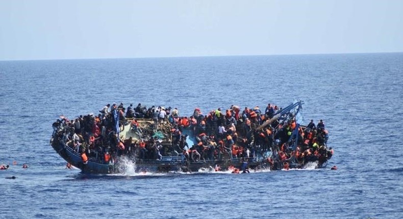 Migrants are seen on a capsizing boat before a rescue operation by Italian navy ships Bettica and Bergamini (unseen) off the coast of Libya in this handout picture released by the Italian Marina Militare on May 25, 2016. 