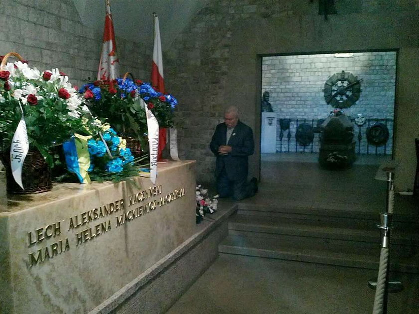 Lech Wałęsa klęczy przy grobie Kaczyńskich