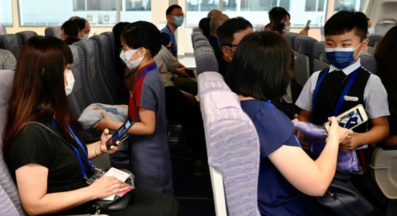 Children act as flight attendants in a mock cabin before a sightseeing 'flight to nowhere' later in the day