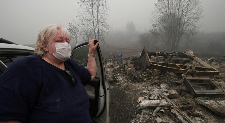 Margi Wyatt stands in front of her incinerated mobile home