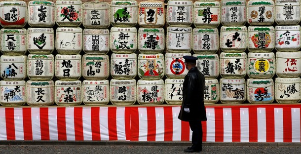 A guard stands in front of barrels of dedicatory Japanese Sake for celebrating the upcoming New Year