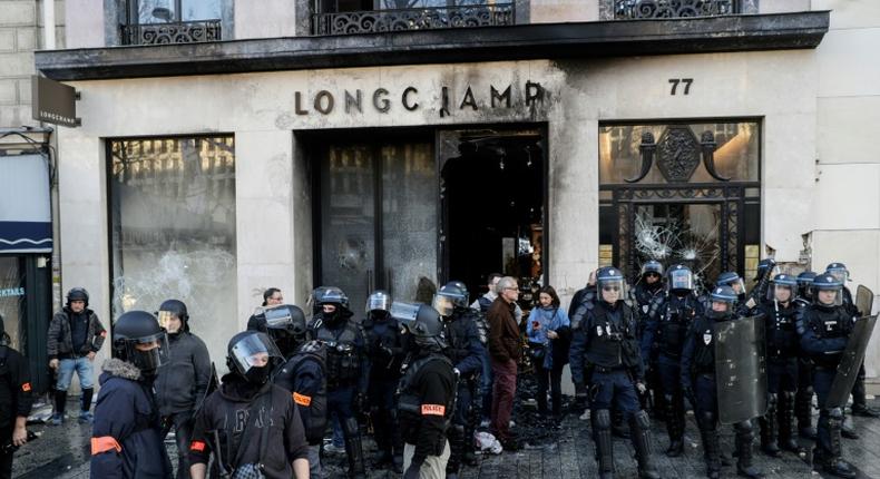 Riot police outside a partially burned Longchamps store on the Champs-Elysees in Paris on Saturday