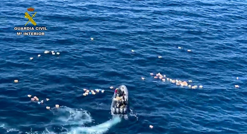 This handout picture released by the Spanish Guardia Civil shows a speedboat surrounded by bundles of drugs in the sea, after a police high-speed chase with drug-smugglers, off the coast of Mijas, Malaga, southern Spain