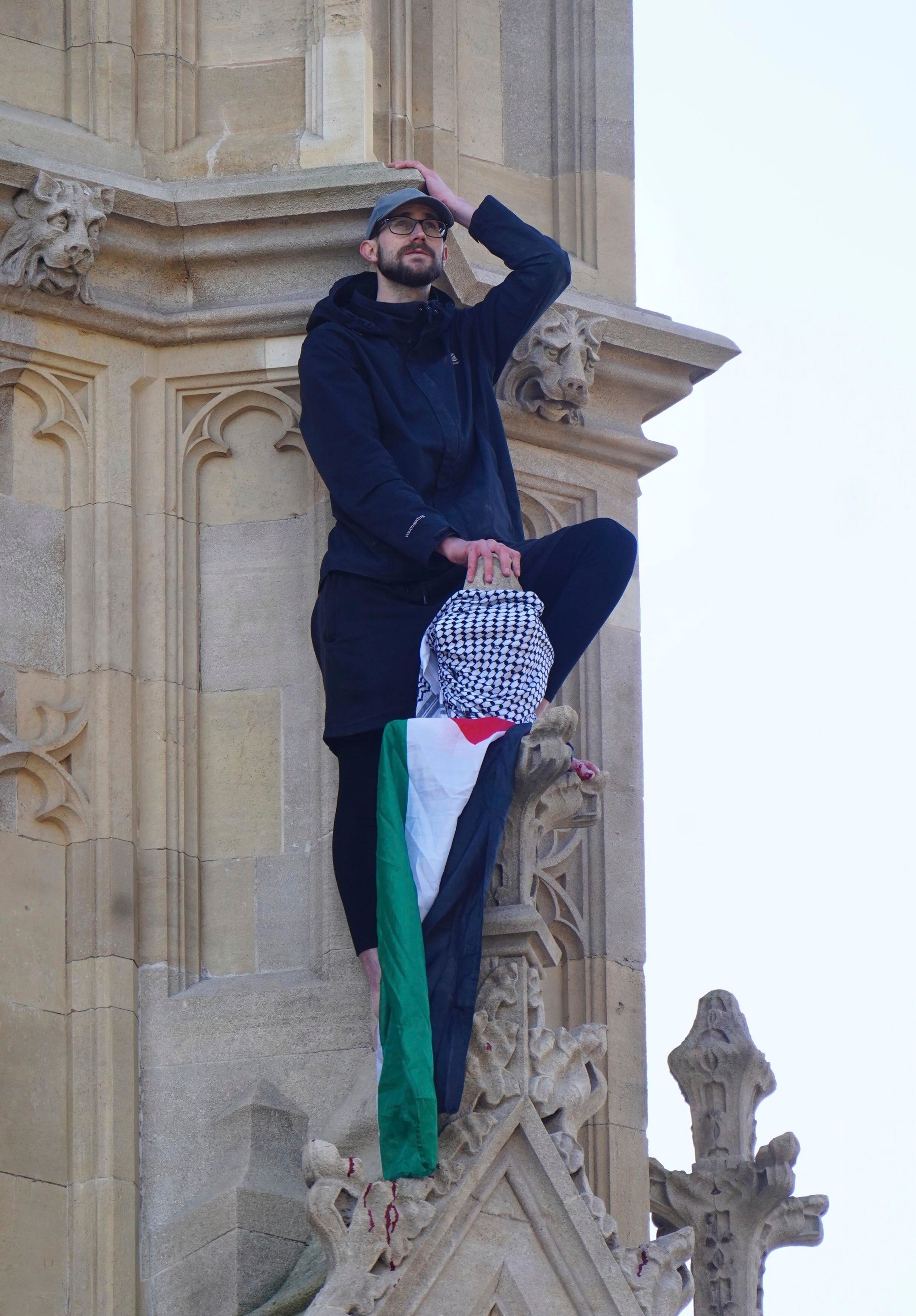 Na snímke muž s palestínskou vlakou, ktorý sa vyšplhal na Big Ben (oficiálne Alžbetina veža) Westminsterského paláca v Londýne v sobotu 8. marca 2025.