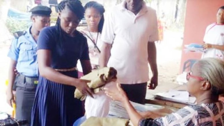 One of the two sacked female corps members returning her kits before being escorted out of the Ebonyi NYSC camp on Sunday, November 10, 2019.  (Punch)