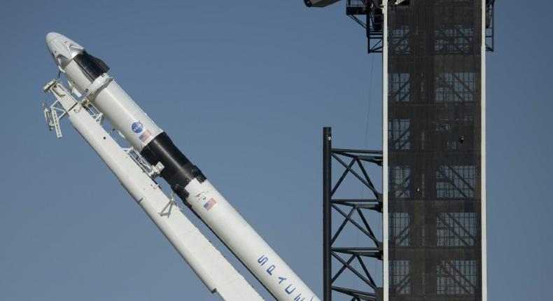 SpaceX's Falcon 9 rocket is raised into a vertical position on the launch pad ahead of the crewed mission to the International Space Station