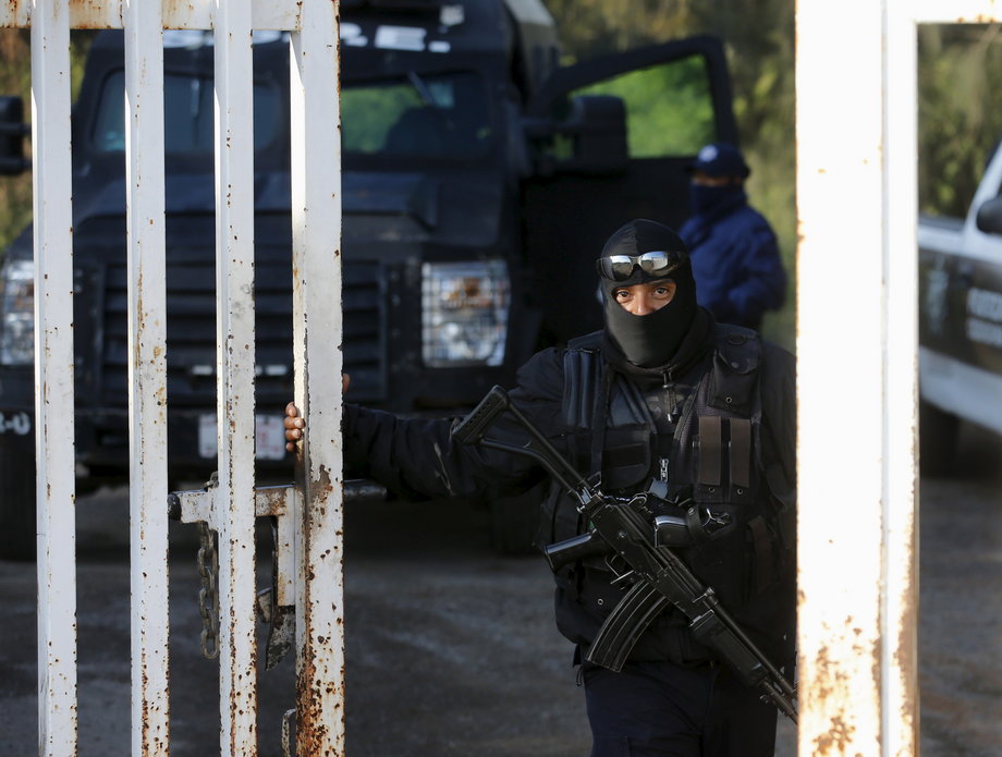 A police officer stands guard at an entrance to a ranch where a firefight took place on Friday in Tanhuato, state of Michoacan, May 23, 2015.