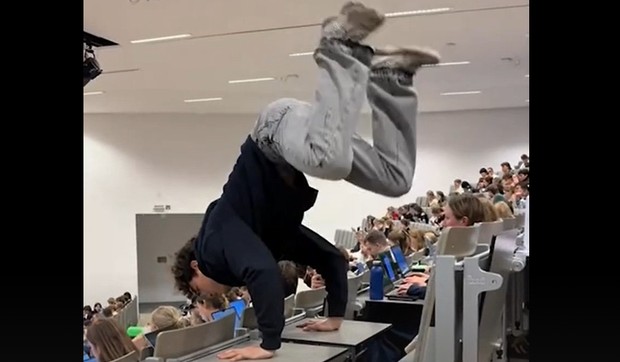 Student radio stoj na rukama u amfiteatru