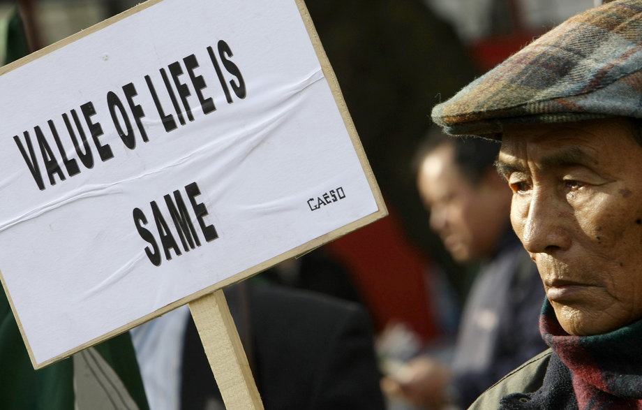 Former Gurkha soldiers and their supporters hold placards outside the High Court in London.