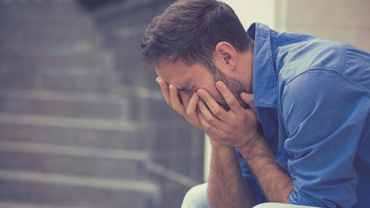 stressed sad crying man sitting outside