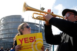 Demonstrators take part in a protest in front of the European Parliament as MEPs debate on modificat