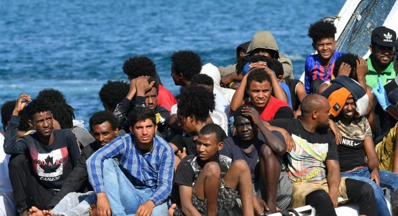 Migrants from Tunisia and Libya arrive onboard of an Italian Coast Guard boat on the Italian island of Lampedusa on August 1