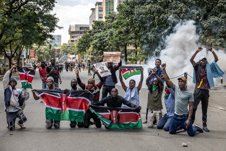 Protesters hold Kenyan flags and chant anti-government slogans as clashes erupt between demonstrators and police during a protest over the death of Kenyan blogger Albert Ojwang, who died in police custody, as the government presents the 2025-2026 budget statement in downtown Nairobi on June 12, 2025. [Photo by LUIS TATO/AFP via Getty Images]