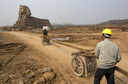 Labourers transport steel bars toward a full-scale replica of the Sphinx at an unfinished movie and animation tourism theme park, in Chuzhou