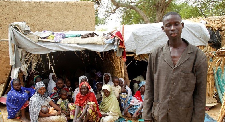 Aba Ali, a Nigerian refugee who fled from his village in northeastern Nigeria into Niger following Boko Haram attacks, stands next to his relatives at the home of Adamu Moumouni, his Nigerien host who took them in, in Diffa in southeastern Niger June 21, 2016. Picture taken June 21, 2016. REUTERS/Luc Gnago