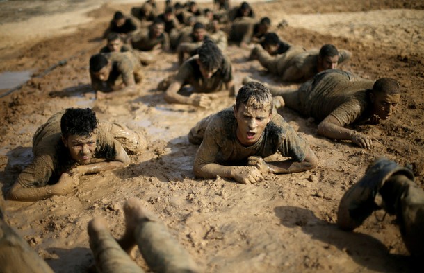 Young Palestinians crawl during a military-style exercise at a Hamas summer camp in Rafah in the sou