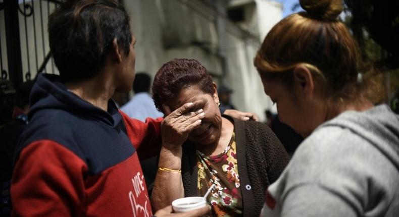 Relatives of the victims of a fire at a government-run children's shelter in San Jose Pinula, cry outside the morgue in Guatemala City