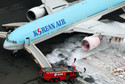 An aerial picture shows fire fighters spraying foam at the engine of a Korean Air Lines plane after smoke rose from it at Haneda airport in Tokyo