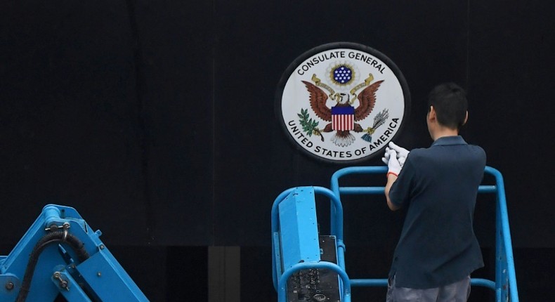 A worker removes the Great Seal of the United States from the front of the US consulate in the Chinese city of Chengdu