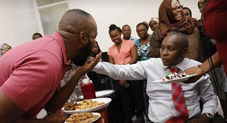 Joho's Communications Director, Richard Chacha giving his boss a cake during his birthday