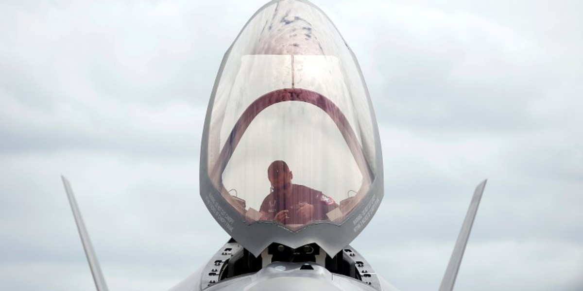 A ground crew member works in the cockpit of a US Marine Corps Lockheed Martin F-35B fighter jet at the Royal International Air Tattoo at Fairford