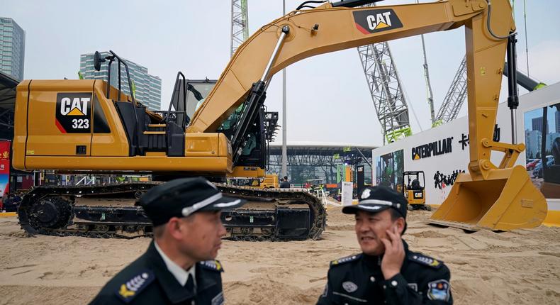 Security guards stand in front of heavy machinery of Caterpillar at Bauma China, the International Trade Fair for Construction Machinery in Shanghai, China November 27, 2018.