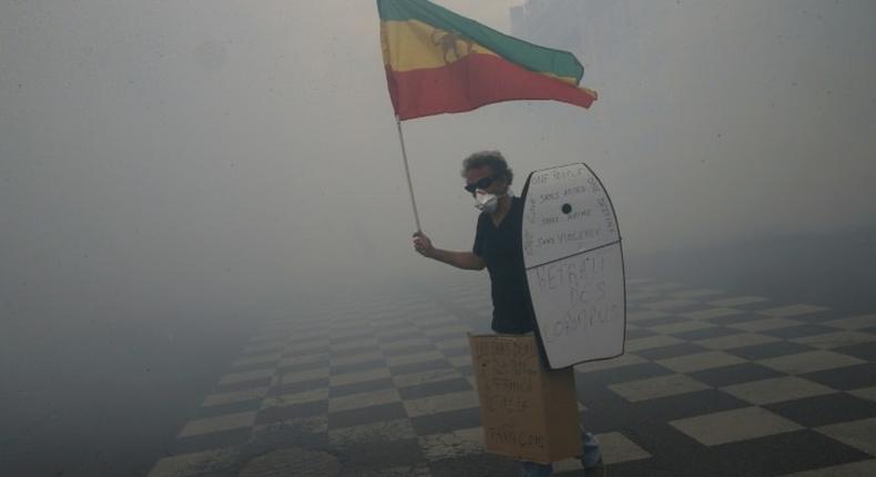 A man holds Ethiopia's former flag as he tries to prevent clashes between protesters and police during a demonstration 