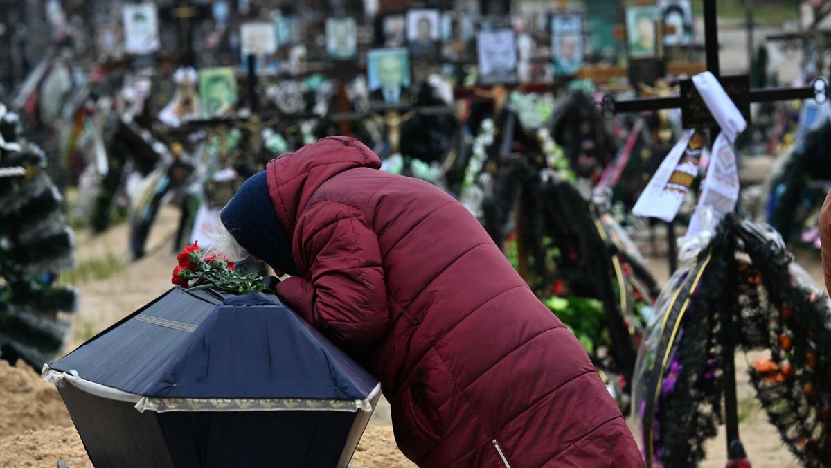 Pogrzeb na cmentarzu w Irpinie, 19 kwietnia 2022 r., gdzie znajdują się co najmniej trzy rzędy nowych grobów poległych podczas rosyjskiej inwazji na Ukrainę. (Zdjęcie: Siergiej SUPIŃSKI / AFP)