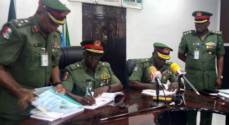 L-R:The outgoing and incoming General Officer Commanding signing the handing and taking over notes at the 81 Division of the Nigerian Army in Lagos [NAN]