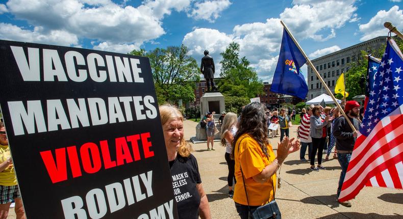 Rally goers hold signs protesting vaccines at the World Wide Rally for Freedom, an anti-mask and anti-vaccine rally, at the State House in Concord, New Hampshire, May 15, 2021.