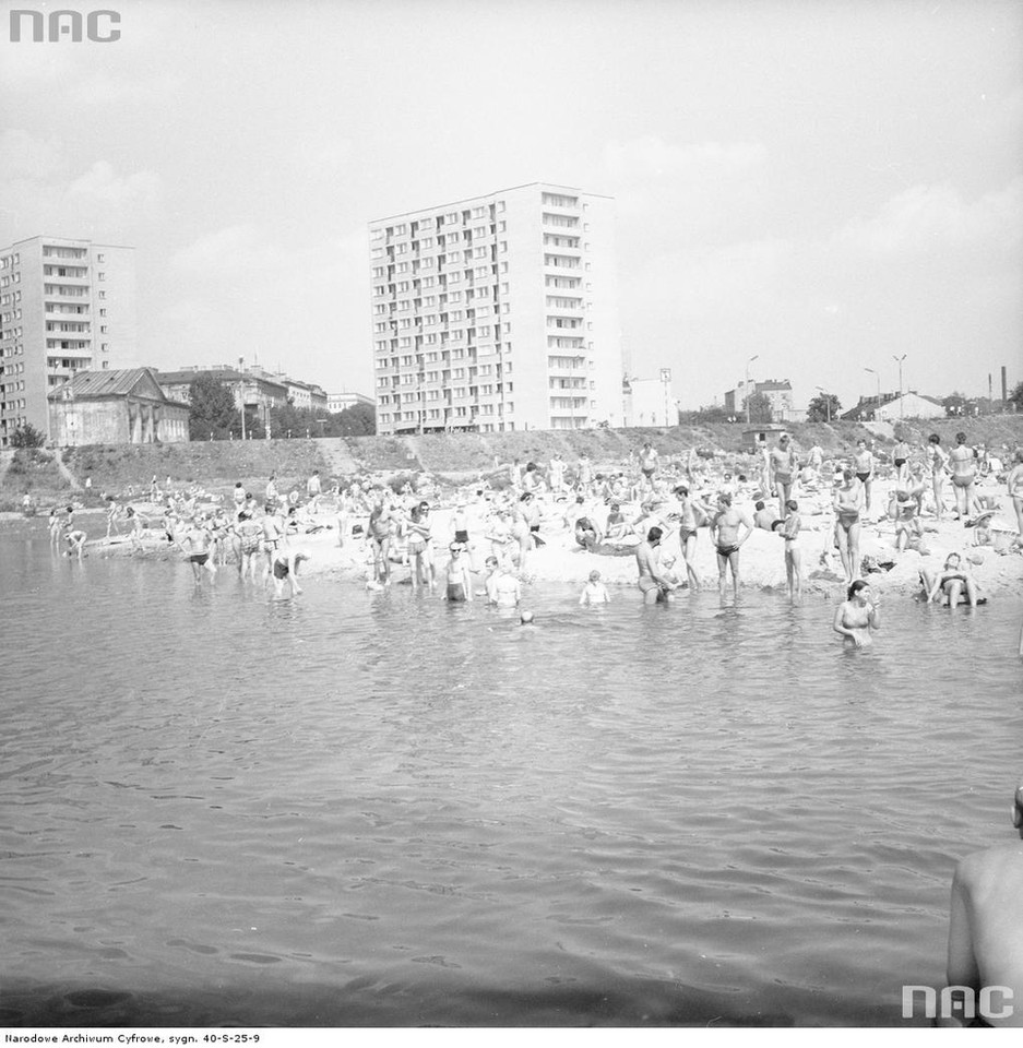 Kąpiący się i wypoczywający na plaży w Warszawie. W oddali zabudowa Pragi, 1969 rok