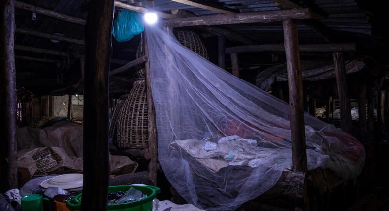 Un vendeur dort sur le marché de Kamapala, dans une moustiquaire afin de se protégéer des moustiques vecteurs du paludisme, le 3 avril 2020 Badru KATUMBA AFP/Archives