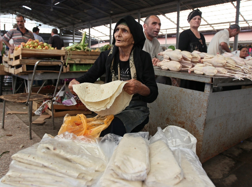 Starsza kobieta sprzedaje własnej roboty pszenne placki