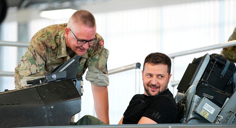 Ukrainian President Volodymyr Zelensky (R) reacts as he sits in a F-16 fighter jet in the hangar of the Skrydstrup Airbase in Vojens, northern Denmark, on August 20, 2023.MADS CLAUS RASMUSSEN/Ritzau Scanpix/AFP via Getty Images
