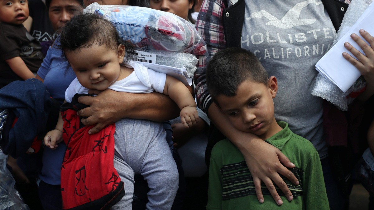 Children of undocumented immigrant families react as they are released from detention at a bus depot