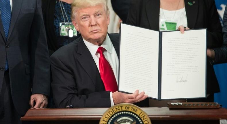 US President Donald Trump signs an executive order to start the Mexico border wall project, at the Department of Homeland Security facility in Washington, DC, on January 25, 2017