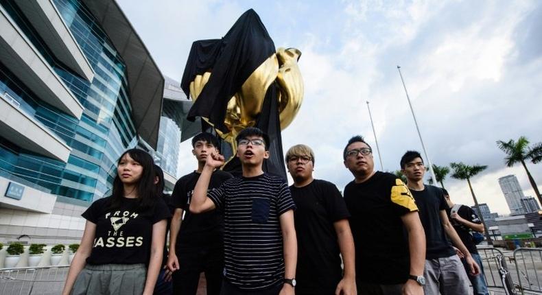 High-profile student campaigner Joshua Wong and a dozen demonstrators attached the black cloth to the giant golden bauhinia flower on Hong Kong's harbourfront in an early morning protest