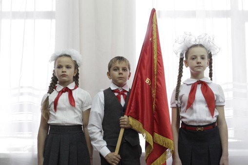 Children attend a ceremony for the inauguration of new members of the Pioneer Organization in Stavro