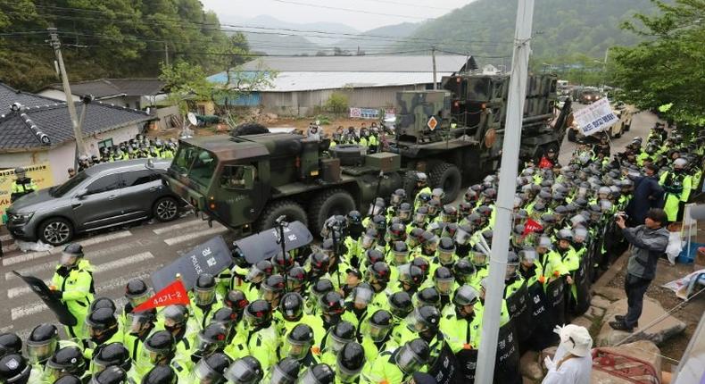 Protesters and police gather to watch as trailers carrying US THAAD missile defence equipment enter a deployment site in Seongju, South Korea