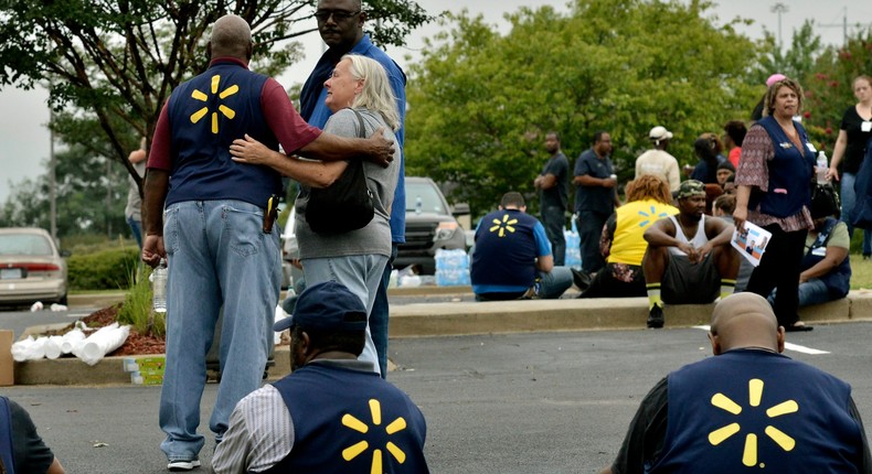 FILE - In this July 30, 2019, file photo Walmart employees gather in a nearby parking lot after a shooting at the store in Southaven, Miss. The discounter has dealt with thousands of violent crimes at its stores across the country, including one that took place less than a week ago at a store in Mississippi where a disgruntled worker killed two co -workers and wounded a police officer. (AP Photo/Brandon Dill, File)