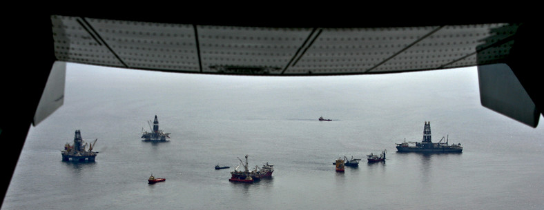 Platformy wiertnicze i statki, które tamują wyciek ropy i zbierają ją z powierzchni. Fot. Bloomberg