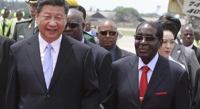 Chinese President Xi Jinping walks with Zimbabwean President Robert Mugabe on arrival for a state visit in Harare, Zimbabwe December 1, 2015. REUTERS/Philimon Bulawayo