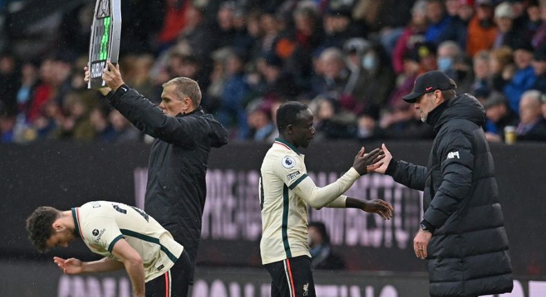 Liverpool forward Sadio Mane (C) taps hands with manager Jurgen Klopp (R) after being substituted during a Premier League match at Burnley on February 13. Creator: Paul ELLIS