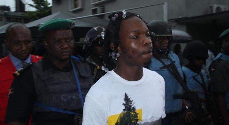 Naira Marley being led to court by men of the EFCC amidst a watertight security. [Twitter/@officialEFCC]