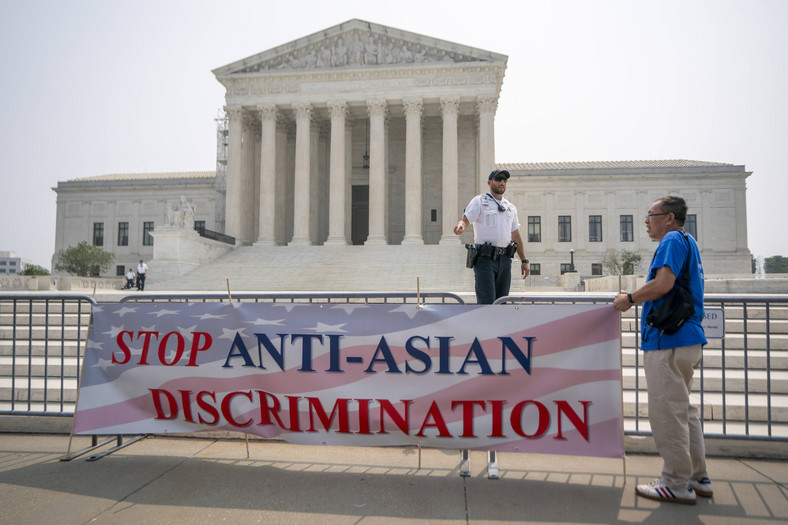 Aktywista z organizacji Students for Fair Admissions stoi obok transparentu  z napisem "Stop antyazjatyckiej dyskryminacji", świętując pozytywnej opinii w Sądzie Najwyższym w Waszyngtonie, USA, 29 czerwca 2023 r.