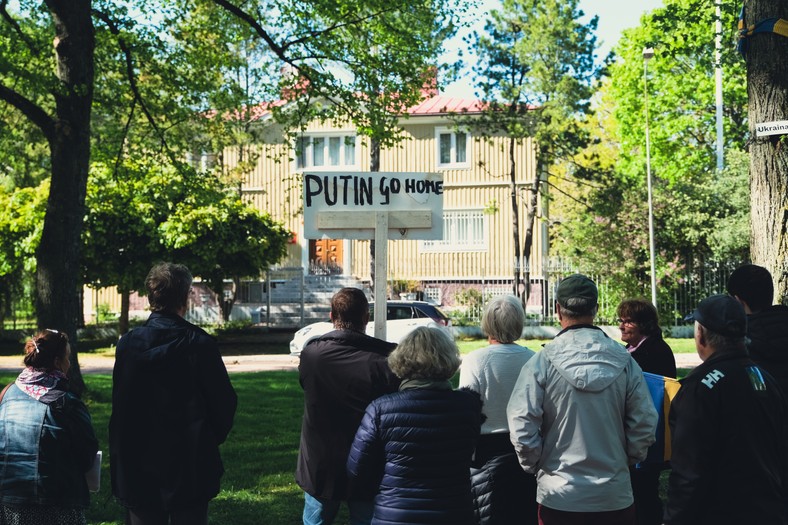 Mężczyzna trzymający tabliczkę z napisem "Putin Go Home" podczas protestu przed rosyjskim konsulatem w Mariehamn, Finlandia, 1 czerwca 2022 r.