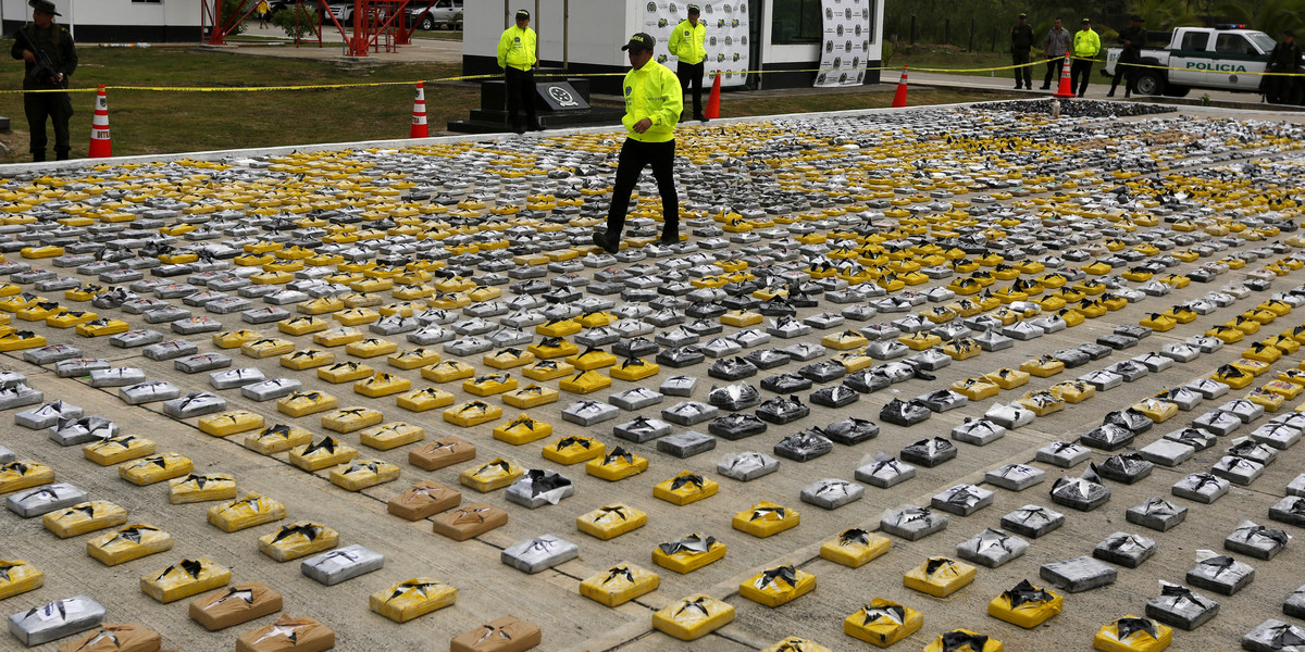 A Colombian anti-narcotics policeman walks on packs of cocaine at the police base in Necocli February 24, 2015.